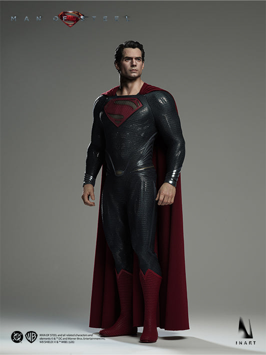 Full-body side view of the INART Man of Steel Superman figure wearing the black Kryptonian suit and red cape